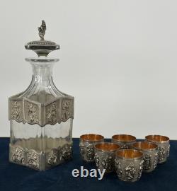 Antique Indonesian liqueur set with silver deity motifs, crystal decanter, and goblets