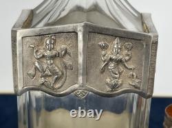 Antique Indonesian liqueur set with silver deity motifs, crystal decanter, and goblets