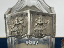 Antique Indonesian liqueur set with silver deity motifs, crystal decanter, and goblets