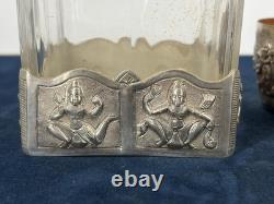 Antique Indonesian liqueur set with silver deity motifs, crystal decanter, and goblets