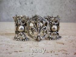 Antique solid silver bracelet with fleur-de-lys, lion, and cherub crest