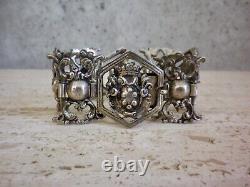 Antique solid silver bracelet with fleur-de-lys, lion, and cherub crest