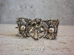 Antique solid silver bracelet with fleur-de-lys, lion, and cherub crest