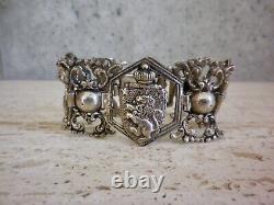 Antique solid silver bracelet with fleur-de-lys, lion, and cherub crest