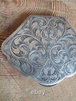Antique solid silver powder box with finely carved floral decoration.