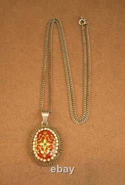 Old antique pendant in solid silver and Bressan enamels, red background